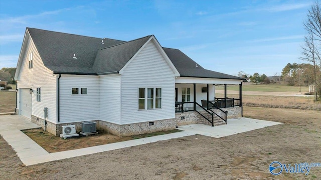 view of side of home featuring crawl space, covered porch, a shingled roof, and cooling unit