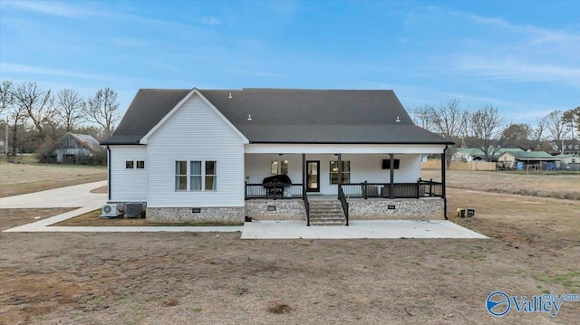 rear view of house with covered porch, central AC, a yard, and crawl space