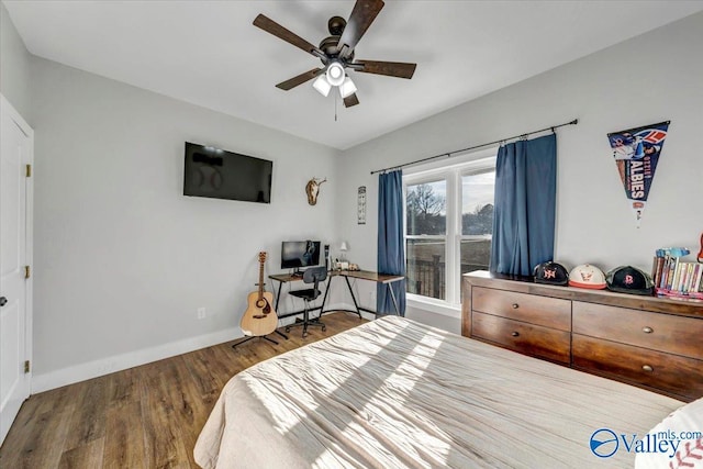 bedroom with a ceiling fan, baseboards, and wood finished floors