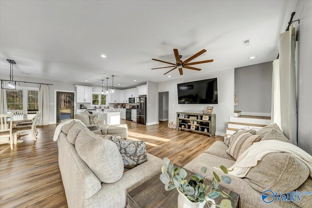 living area featuring a healthy amount of sunlight, wood finished floors, and recessed lighting