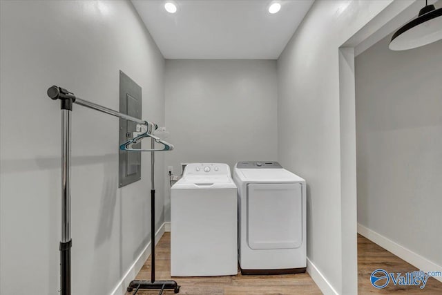 laundry room with laundry area, washer and clothes dryer, baseboards, and wood finished floors