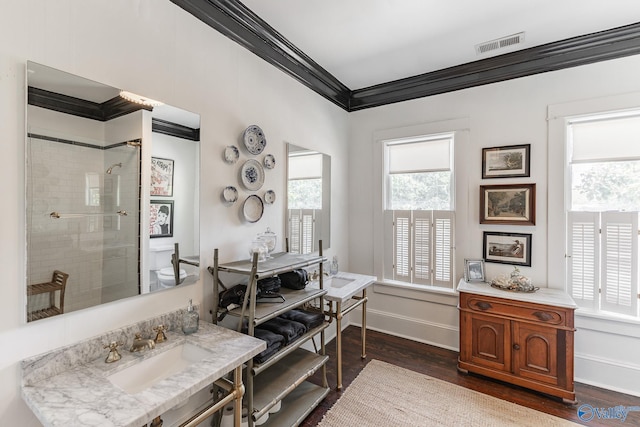 bathroom with a healthy amount of sunlight, sink, hardwood / wood-style floors, and a tile shower