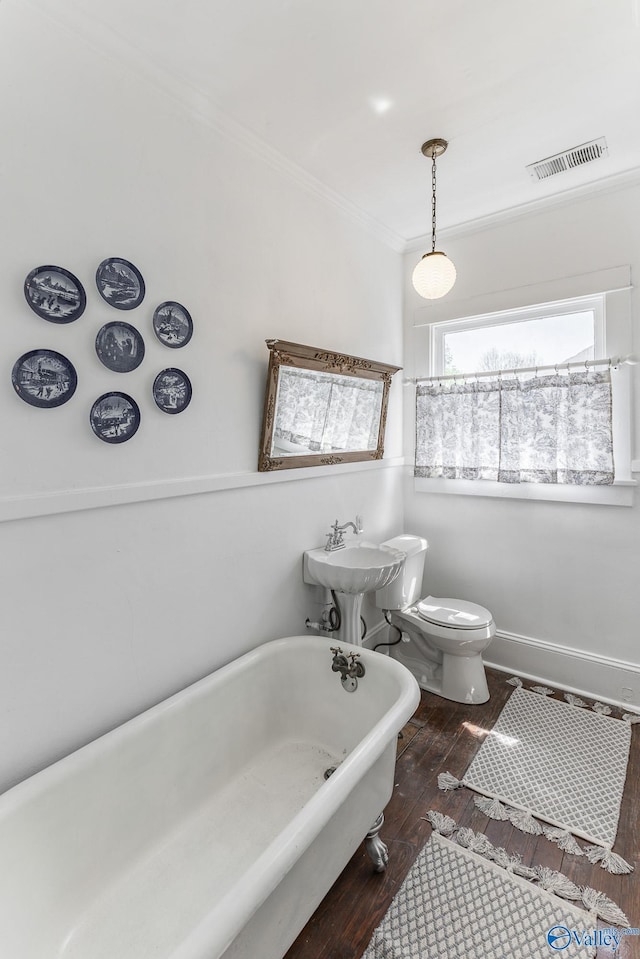 bathroom featuring hardwood / wood-style floors, sink, a tub to relax in, ornamental molding, and toilet