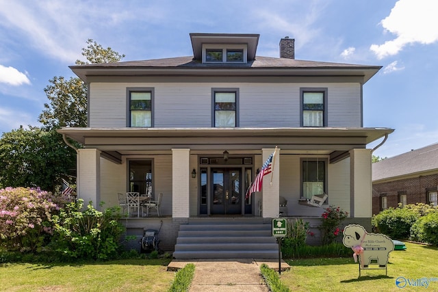 view of front facade with a porch, a front lawn, and french doors