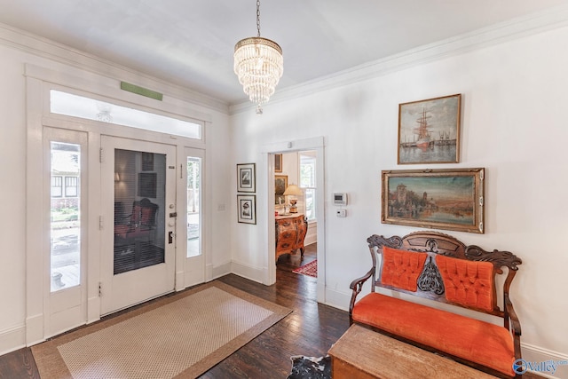 entrance foyer featuring crown molding, plenty of natural light, dark hardwood / wood-style floors, and a chandelier