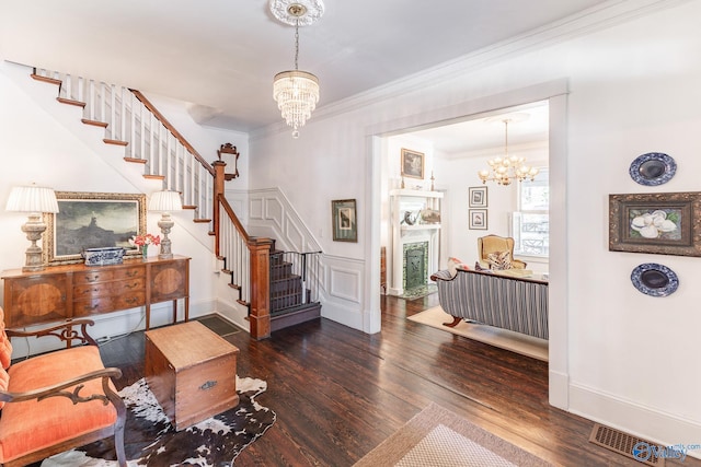 foyer featuring ornamental molding, dark wood-type flooring, and a chandelier