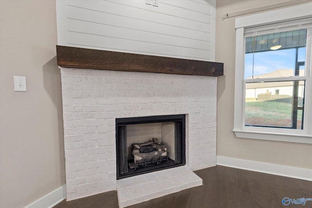 interior details featuring hardwood / wood-style flooring and a brick fireplace