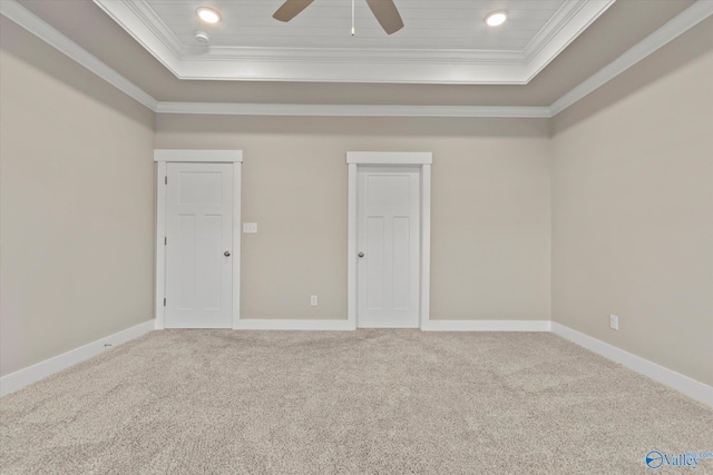 unfurnished bedroom with carpet, a tray ceiling, and ornamental molding