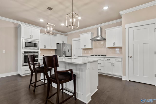 kitchen with appliances with stainless steel finishes, dark wood-type flooring, wall chimney range hood, and sink