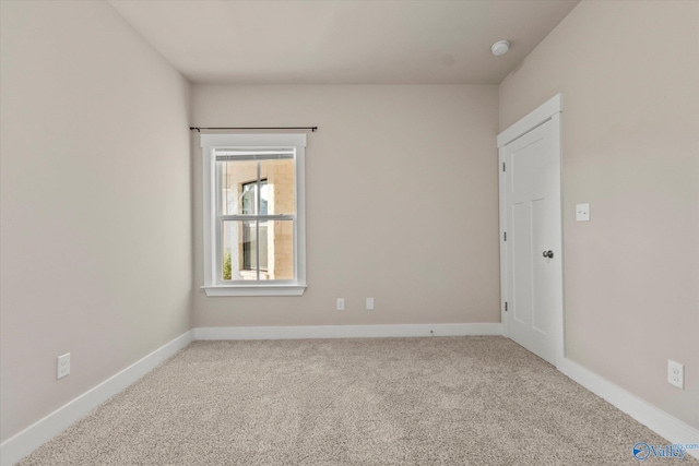 spare room featuring light colored carpet