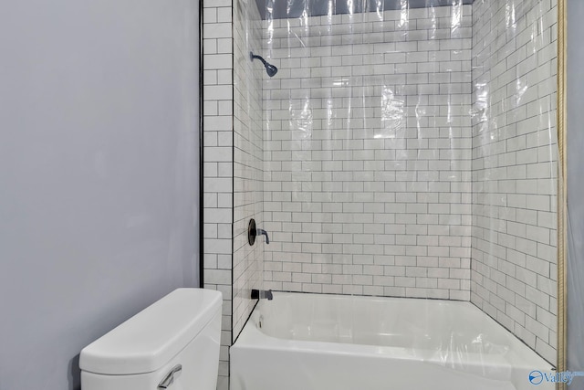 bathroom featuring shower / tub combination and toilet