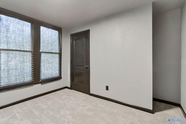 carpeted empty room with baseboards