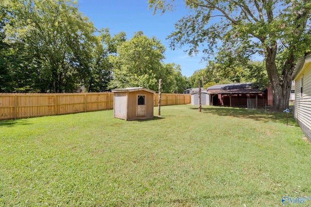 view of yard with an outdoor structure, a storage shed, and a fenced backyard