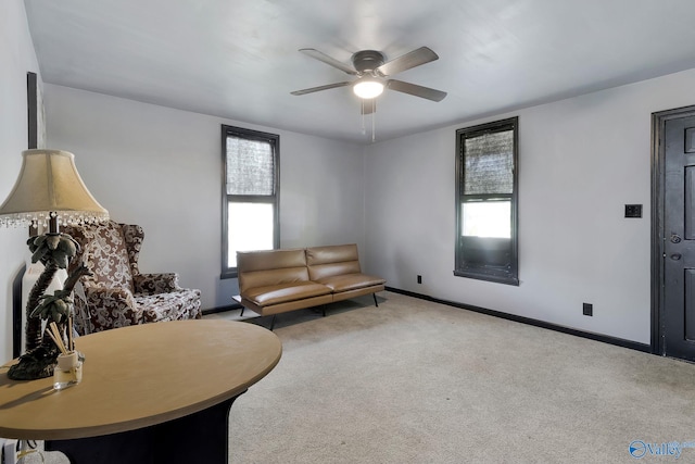 living area featuring carpet flooring, a ceiling fan, baseboards, and a wealth of natural light