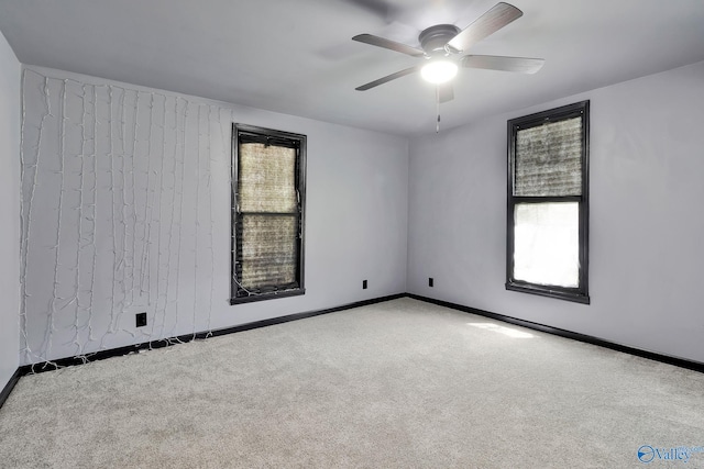 carpeted empty room with baseboards and ceiling fan