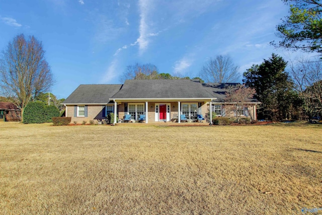 view of front facade with covered porch, a front yard, and brick siding