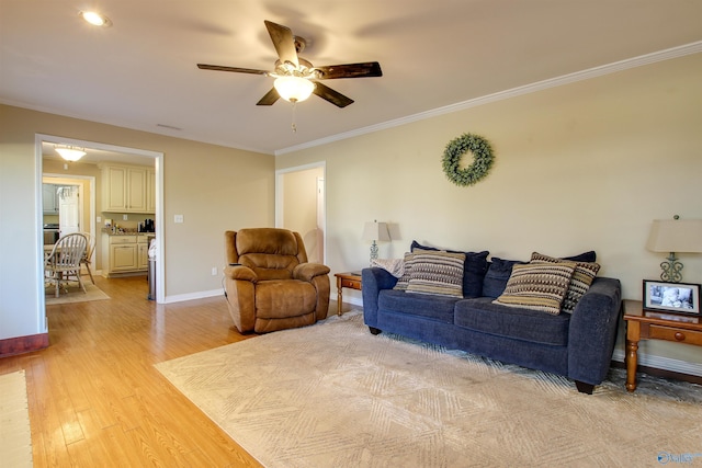 living room with crown molding, ceiling fan, and light wood-type flooring