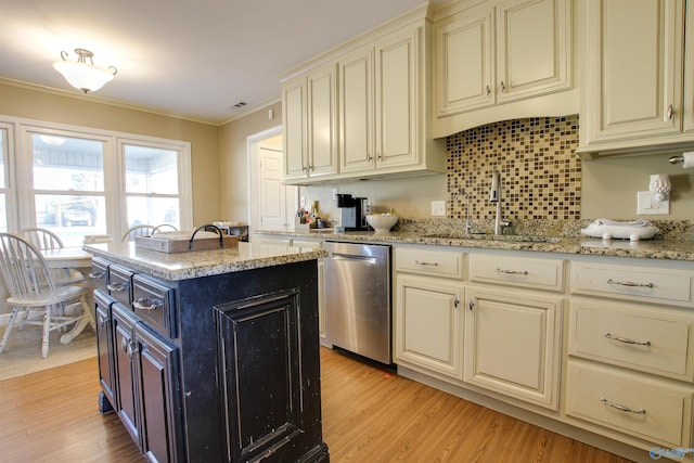 kitchen featuring sink, ornamental molding, dishwasher, a kitchen island, and cream cabinetry