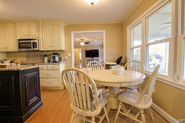 dining area featuring ornamental molding, ceiling fan, and light hardwood / wood-style flooring