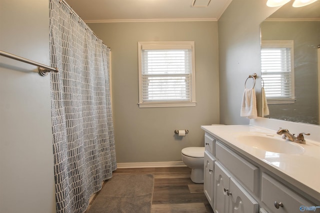 bathroom featuring hardwood / wood-style floors, ornamental molding, a wealth of natural light, and vanity