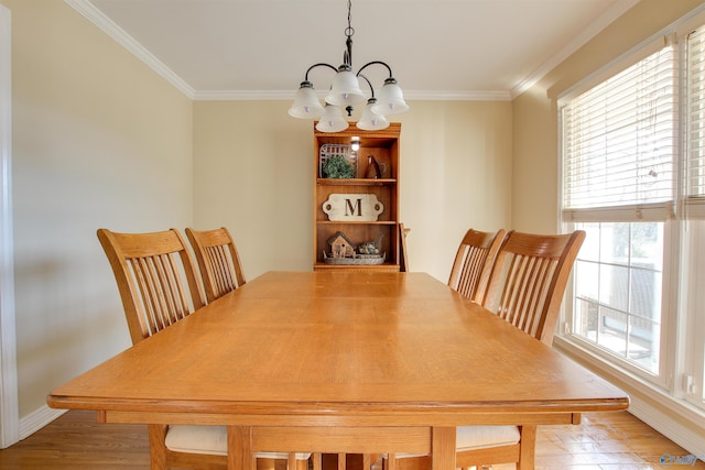 dining area with hardwood / wood-style flooring, ornamental molding, and an inviting chandelier