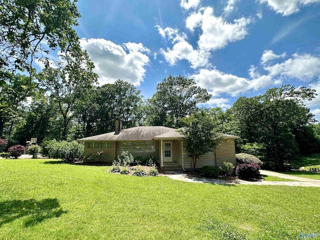 single story home with a chimney and a front yard