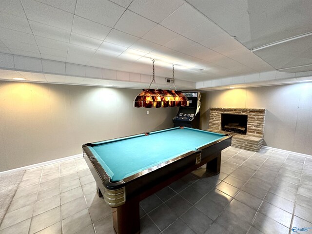 game room with pool table, tile patterned flooring, baseboards, and a stone fireplace