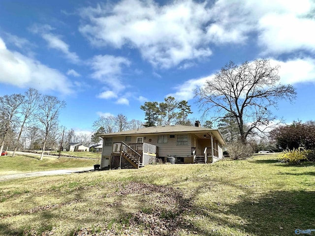 back of property featuring stairs, a yard, a chimney, and central air condition unit