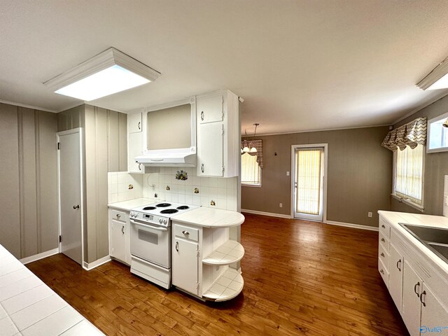 kitchen with white cabinetry, dark hardwood / wood-style flooring, electric stove, and tile counters