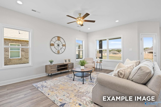 living room featuring recessed lighting, baseboards, and wood finished floors