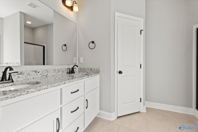 bathroom featuring tile patterned flooring, vanity, and walk in shower