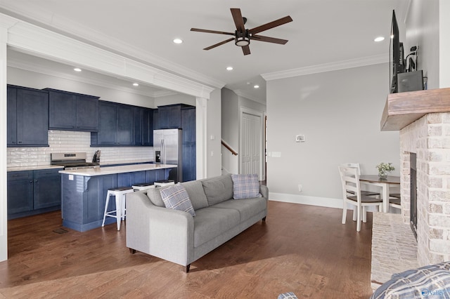 living room with baseboards, a fireplace with raised hearth, a ceiling fan, dark wood-style floors, and recessed lighting