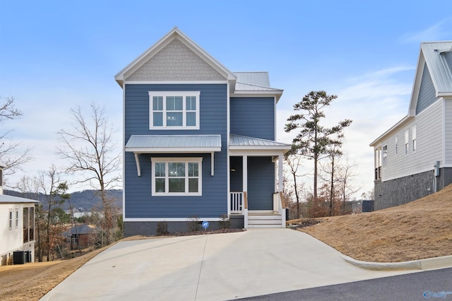 view of front of home with covered porch, metal roof, and central AC unit