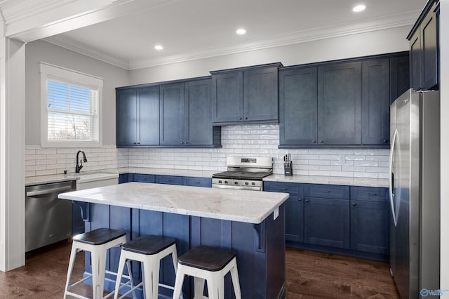 kitchen with stainless steel appliances, a sink, dark wood finished floors, a kitchen bar, and crown molding