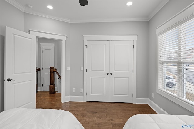 bedroom featuring crown molding, a closet, dark wood finished floors, and baseboards