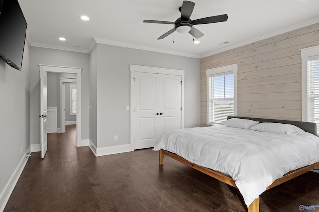 bedroom featuring baseboards, dark wood-style flooring, crown molding, a closet, and recessed lighting