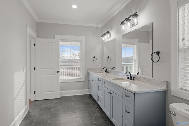 full bathroom with toilet, crown molding, baseboards, and a sink