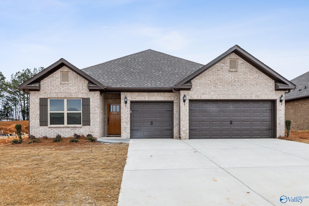 112 Huffman St, Hazel Green, AL 35750 - view of front of house with brick siding, an attached garage, a shingled roof, and concrete driveway
