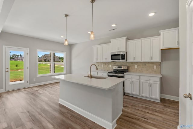 kitchen with decorative backsplash, light hardwood / wood-style flooring, white cabinetry, range, and sink