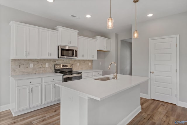 kitchen with sink, a center island with sink, light hardwood / wood-style floors, and stainless steel appliances