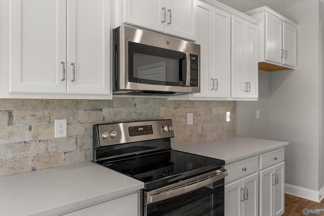 kitchen featuring appliances with stainless steel finishes, decorative backsplash, white cabinets, and wood-type flooring