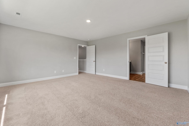 unfurnished bedroom featuring a walk in closet and carpet floors