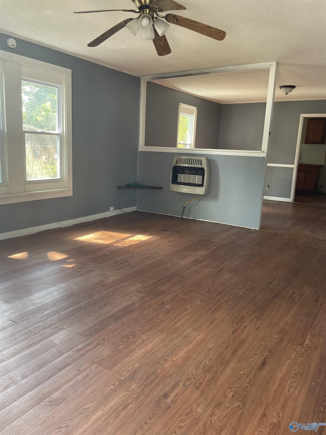 spare room with hardwood / wood-style flooring, a textured ceiling, and heating unit