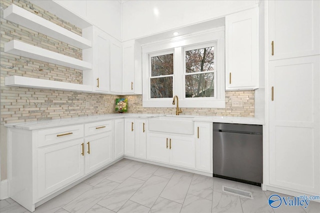 kitchen featuring sink, light stone counters, stainless steel dishwasher, backsplash, and white cabinets