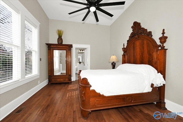 bedroom with lofted ceiling, ceiling fan, dark wood-type flooring, and connected bathroom