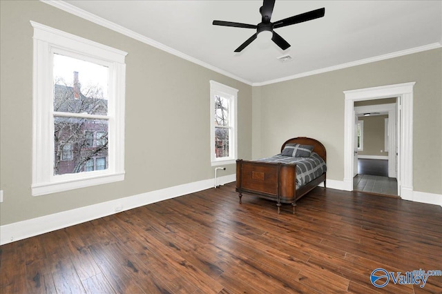 bedroom featuring ceiling fan, dark hardwood / wood-style flooring, ensuite bathroom, and crown molding