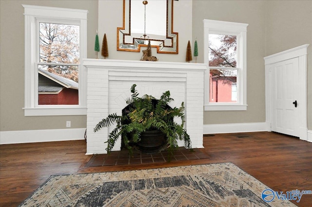 living room with plenty of natural light, dark hardwood / wood-style floors, and a fireplace