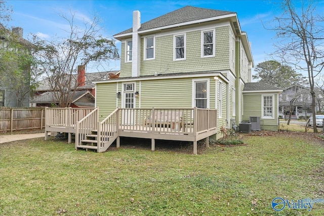 rear view of house featuring a lawn, cooling unit, and a wooden deck