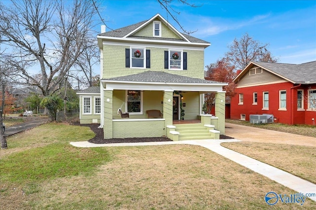 view of front facade with a porch, a front yard, and central AC