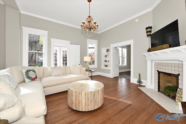 living room with dark hardwood / wood-style floors, a fireplace, a wealth of natural light, and an inviting chandelier